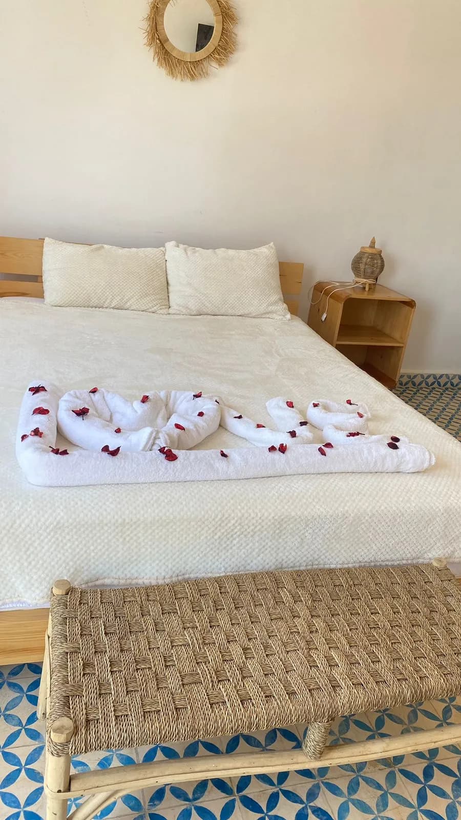 Chambre aux tons crème, lit habillé de lin et sol en zellige